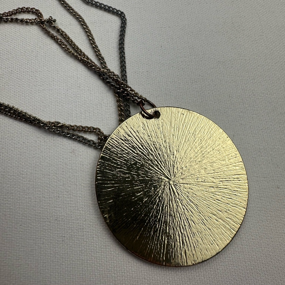 Faux gold large circle pendant long necklace and gold stud earrings.